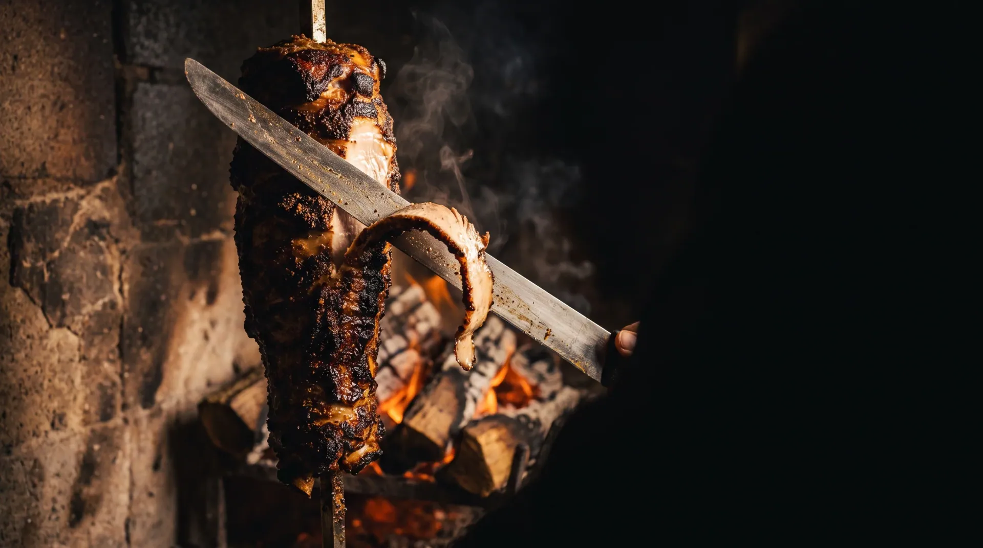 The spit — Layer on layer, eight hours over coals. Only the outer edge comes off.
